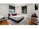 Stylish bedroom featuring a gray platform bed, natural light from two windows, and hardwood floors at 819 Belgrade Ne Ave, Atlanta, GA 30306
