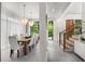 Bright dining room with wooden table, white walls, chandeliers, hardwood stairs, and outdoor view at 819 Belgrade Ne Ave, Atlanta, GA 30306