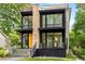 Contemporary two-story home boasting floor-to-ceiling windows, stone details, and lush greenery at 819 Belgrade Ne Ave, Atlanta, GA 30306