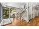 Bright foyer featuring hardwood floors, modern staircase with glass railings, and large windows with natural light at 819 Belgrade Ne Ave, Atlanta, GA 30306