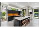 Bright kitchen with island, stool seating, sleek black cabinets, and big windows bringing nature indoors at 819 Belgrade Ne Ave, Atlanta, GA 30306
