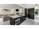 Open concept kitchen and living room with black island, stainless appliances, and hardwood floors at 819 Belgrade Ne Ave, Atlanta, GA 30306