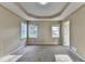 Spacious bedroom featuring neutral carpeting, ample natural light, and a tray ceiling design at 1400 Scenic Brook Sw Trl, Conyers, GA 30094