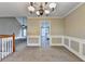Open-concept space exhibiting neutral paint, staircase and entry to the adjacent kitchen at 1400 Scenic Brook Sw Trl, Conyers, GA 30094