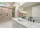 Bathroom featuring dual vanity sinks, a walk-in shower, and marble countertops at 1911 Woodmont Ct, Marietta, GA 30062