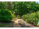 Landscaped backyard with stone pathway, vibrant foliage, and a tranquil setting, perfect for relaxation at 200 Glenview Ct, Woodstock, GA 30188