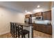 Finished basement bar area featuring dark cabinetry, a microwave, a sink, and seating for four at 200 Glenview Ct, Woodstock, GA 30188