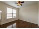 Bright bedroom featuring a ceiling fan, large window with blinds, and gleaming hardwood floors at 200 Glenview Ct, Woodstock, GA 30188