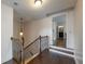 Upstairs hallway with an ornate light fixture, dark hardwood floors, and a doorway into the bathroom at 200 Glenview Ct, Woodstock, GA 30188