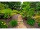 Beautifully landscaped backyard garden area with stone steps, mature trees, and lush plants at 200 Glenview Ct, Woodstock, GA 30188