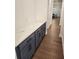 Hallway features a counter with modern blue cabinets and dark hardware, leading into the dining room at 2949 Longbush, Duluth, GA 30097