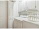 All white laundry room with front load washer/dryer and cabinets for ample storage space at 3333 Old Salem Se Rd, Conyers, GA 30013