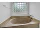 Soaking tub area with natural light from glass block window at 5080 Brownwood Dr, Powder Springs, GA 30127