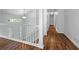 Well-lit hallway with wood flooring and modern white railing at 5080 Brownwood Dr, Powder Springs, GA 30127