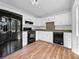 Well-equipped kitchen with white cabinets, modern appliances, and hardwood floors at 5080 Brownwood Dr, Powder Springs, GA 30127
