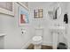 Clean, minimalist bathroom with a pedestal sink, toilet, and tasteful artwork, maximizing space and style at 845 Spring Nw St # 129, Atlanta, GA 30308