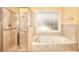 Bathroom featuring shower stall, and soaking tub next to window at 1595 Lake Lucerne Rd Sw, Lilburn, GA 30047