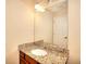 Bathroom featuring granite vanity, sink, mirror, lighting, and door at 1595 Lake Lucerne Rd Sw, Lilburn, GA 30047