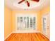 Bedroom features hardwood floors, ceiling fan, shuttered windows and door to the exterior at 1595 Lake Lucerne Rd Sw, Lilburn, GA 30047