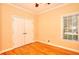 Bedroom featuring closet doors, window, and hardwood floors at 1595 Lake Lucerne Rd Sw, Lilburn, GA 30047