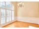 Bright dining room features wainscoting, hardwood floors, large windows with shutters and elegant chandelier at 1595 Lake Lucerne Rd Sw, Lilburn, GA 30047