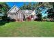 Beautiful brick house with well-manicured lawn and mature trees providing shade at 1595 Lake Lucerne Rd Sw, Lilburn, GA 30047