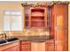 Well-lit kitchen features custom wood cabinets, stone countertops, tile backsplash and stainless steel appliances at 1595 Lake Lucerne Rd Sw, Lilburn, GA 30047