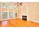 Sunlit living room boasts hardwood floors, large windows, and a cozy fireplace at 1595 Lake Lucerne Rd Sw, Lilburn, GA 30047