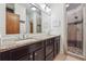 Bathroom featuring a double sink vanity with granite countertops and a tiled shower with a glass door at 1802 Dekalb Ne Ave, Atlanta, GA 30307