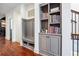 Well-organized mudroom area with built-in bench, hooks, storage shelves, and hardwood floors at 1802 Dekalb Ne Ave, Atlanta, GA 30307