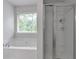 Bright bathroom featuring a separate shower, soaking tub, and window at 2735 Maple Park Pl # 32, Cumming, GA 30041