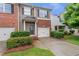 Two-story townhome featuring brick, single car garage, and landscaped front yard at 2735 Maple Park Pl # 32, Cumming, GA 30041