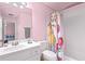 Cozy bathroom with a sink, toilet, mirror, and a shower/tub with bright, patterned curtain at 321 River Green Ave, Canton, GA 30114