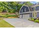 Spacious driveway leads to a three-car garage, surrounded by lush landscaping at 321 River Green Ave, Canton, GA 30114