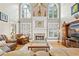 Elegant living room featuring a cozy fireplace, large windows, and comfortable leather seating at 321 River Green Ave, Canton, GA 30114