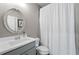 Neutral bathroom with white vanity, a mirror and bathtub with a white curtain at 6840 Canyon Creek Way, Cumming, GA 30028
