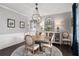 Stylish dining area with round table, elegant chandelier, and ample natural light at 6840 Canyon Creek Way, Cumming, GA 30028