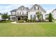 Beautiful home featuring manicured lawn, stone accents, and classic architectural details at 6840 Canyon Creek Way, Cumming, GA 30028