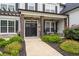 Inviting front porch with stone columns and charming seating area at 6840 Canyon Creek Way, Cumming, GA 30028