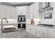 Bright kitchen featuring white cabinets, stainless steel appliances, granite countertops, and a subway tile backsplash at 6840 Canyon Creek Way, Cumming, GA 30028
