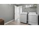 Functional laundry room equipped with modern washer and dryer, and storage shelves at 6840 Canyon Creek Way, Cumming, GA 30028