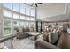 Spacious open floor plan, living room with large windows, gray sofas, ottoman, and partial view of the kitchen at 6840 Canyon Creek Way, Cumming, GA 30028