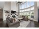 Bright living room with two-story windows, fireplace, built-in bookshelves, and two gray sofas at 6840 Canyon Creek Way, Cumming, GA 30028