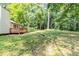 Wide view of the spacious backyard, surrounded by mature trees plus wooden deck at 3120 Westwood Dr, Acworth, GA 30102