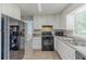 Bright kitchen with white cabinets, black appliances, and wood-look floors at 3120 Westwood Dr, Acworth, GA 30102
