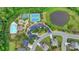 Aerial view of community amenities including a pool, tennis courts, parking, playground and a pond surrounded by trees at 7470 Oldbury Pl, Cumming, GA 30040