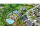 Wide aerial shot showcases a swimming pool, tennis courts, pond, and homes nestled in lush greenery at 7470 Oldbury Pl, Cumming, GA 30040