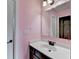 Cozy bathroom featuring a sink vanity and a mirror, painted with pink color at 7470 Oldbury Pl, Cumming, GA 30040