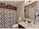 Well-lit bathroom with a framed mirror and a patterned shower curtain at 7470 Oldbury Pl, Cumming, GA 30040