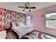 Inviting bedroom featuring a white bed with colorful wallpaper and an area rug at 7470 Oldbury Pl, Cumming, GA 30040